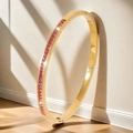 Detailaufnahme eines vergoldeten Armreifs mit rosa Zirkonia-Steinen im natürlichen Licht - Gold Rosa Zirkonia Kanalset-Stil (TT0105) / Rosa