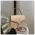 Detail of a minimalist cream PU leather handbag featuring an oval gold metal buckle and handle - Khaki