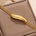 Macro detail of gold wave link bracelet with textured inlay on jewelry box - Frosted Wave Pattern Style (STB25215-GO)