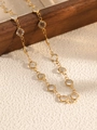 Dettaglio di collana a catena dorata con cristalli tondi incastonati su base di legno - Oro+Bianco