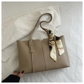 Detail der khakifarbenen Leder-Shopper-Tasche mit Seidenschal und geometrischem Rand - Khaki