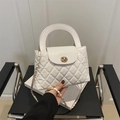 Witte gewatteerde crossbodytas met gouden hardware en kettingriem op een stoel - Wit
