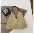 Macro view of woven straw beach bag featuring brown leather shoulder strap and mesh texture - Brown