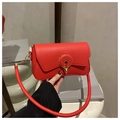 Detailed shot of the red leather handbag featuring a stylish gold circular metal clasp - Red