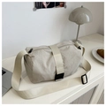 Detail of beige nylon crossbody bag with adjustable strap and buckle on a minimalist desk - Khaki