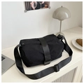 Detail of black nylon cylinder bag showing the plastic buckle strap and top zipper closure - Black