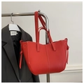 Detail of red pebbled leather tote bag with white contrast stitching and side knot - Red