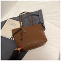 Dettaglio della borsa tote in pelle marrone con nappa e ciondolo in metallo - Con Ciondolo / Marrone