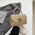 Elegante borsa in pelle intrecciata kaki con fibbia a D dorata in un contesto lifestyle - Cachi
