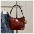 Dettaglio borsa a secchiello in pelle bordeaux con logo fiocco argento e ciondolo orsetto - Con Ornamento / Rosso