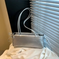 Y2K style silver metallic shoulder bag featuring side bow details and a zipper closure - Silver