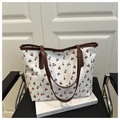 Dettaglio della grande borsa tote bianca con stampe di ciliegie e finiture in pelle marrone - Bianco