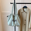 Detail of light green ruched tote bag with brown Beach print and matching wide strap - Green