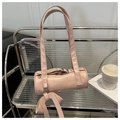 Dettaglio della borsa Boston cilindrica rosa con trama in pelle e ciondolo in nastro - Rosa