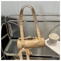 Detalle del bolso Boston beige con asas largas y colgante de cuero en un banco - Rosa
