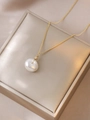 Close-up of a white baroque pearl pendant on a gold chain over a luxury display box - Necklace (X3686)