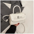 Minimalist white patent leather crossbody bag with top handle and metallic buckle detail - White