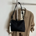 Black tote bag with butterfly embroidery and white tassel detail on a metal hanger - With Charm / Black
