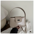 Détail du sac beige verni avec plaque logo métallique et finitions argentées chic - Kaki