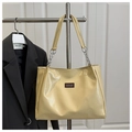 Detailed macro view of beige patent leather tote bag featuring a metal chain handle - No Pendant / Yellow