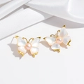 Detailed view of butterfly stud earrings with mother of pearl and pink pearl accents - Earrings