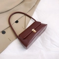 Detailansicht einer dunkelroten Leder-Achseltasche mit elegantem goldenem Verschluss - Burgunderrot