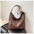 Close-up of deep brown soft PU leather tote bag featuring a front pocket and logo detail - Brown