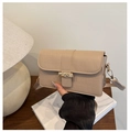Gros plan d'un sac à main beige à motif crocodile et fermoir en bambou doré chic - Kaki