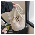 Detailed close-up of beige crochet bucket bag with braided rope handle and tassel detail - Off White