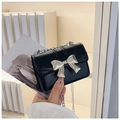 Detail of black mini square bag featuring silver bow metal buckle and chain strap - Black
