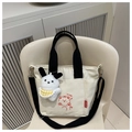 Détail du sac cabas en toile avec motif ours et breloque lapin sur une chaise - Sans pendentif / Noir