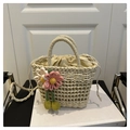Detail der handgefertigten Strohtasche mit Häkelblumen und Kordelzug-Innenfutter - Beige mit Blumenanhänger