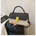 Close-up of contrast crossbody bag with M-letter print and golden metallic twist lock - White