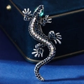 Broche de geco vintage plateado con cristalle azul oscuro y ojos verdes sobre terciopelo - Forma de Gecko