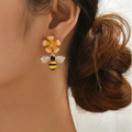 Elegante Blumen und Bienen Ohrstecker mit Kristallen getragen von einem Modell - Bienen-Ohrstecker