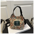 Detailaufnahme der Blumen-Beuteltasche mit rot-blauem Muster und grünem Markenetikett - Rot und Blau Floral (Modell 3)