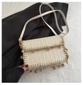 Close-up of beige woven crossbody bag featuring shell charms and a wave-edge flap design - White
