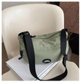 Detail view of the light green nylon half-moon bag with adjustable black strap and logo - Green