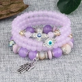 Detail of purple beaded bracelet set with Hamsa hand, cross and evil eye charms - Light Purple