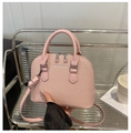 Detailansicht einer rosa gewebten Muscheltasche mit silbernen Metallbeschlägen - Rosa
