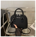 Detailansicht der schwarzen Muschel-Tasche mit Silberbeschlägen und Reißverschlüssen - Schwarz