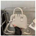 Detailaufnahme der beigen Handtasche mit Webstruktur, Reißverschlüssen und modischem Logo - Beige