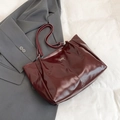 Deep wine red glossy tote bag featuring a delicate gold bow and sleek long handles - Red