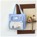 Detail of light blue tote bag featuring transparent front pockets and cloud logo - Blue