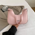 Stijlvolle roze halvemaanvormige schoudertas met metalen strik in de hand - Nude roze