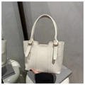 Gros plan sur le cuir grainé et les détails métalliques du sac seau blanc élégant - crème