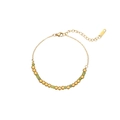 Dettaglio di un bracciale dorato con pietre cilindriche verdi e chiusura a moschettone - Stile in pietra cilindrica verde (B2157-G)