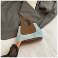 Detail van blauwe denim en bruin leer met decoratieve klinknagels op de handtas - Bruin