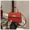 Detalle de bolso de mano rojo con purpurina, cierre giratorio dorado y lentejuelas - Rojo