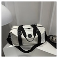Dettaglio della toppa in pelle nera con logo fashion su borsa da viaggio bianca - Bianco